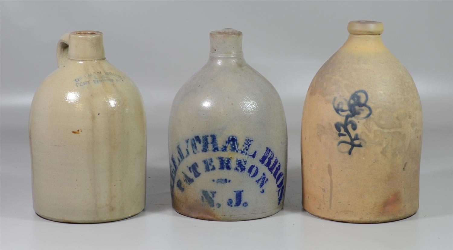 Appraisal: gallon stoneware jugs with blue flower with stenciled Hellthal Bros