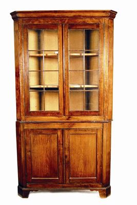 Appraisal: An oak standing corner cupboard with a pair of glazed