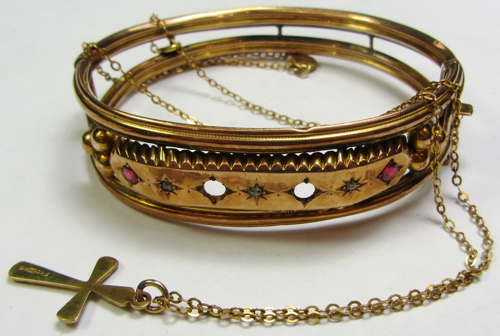 Appraisal: A gold oval hinged bangle on a snap clasp and