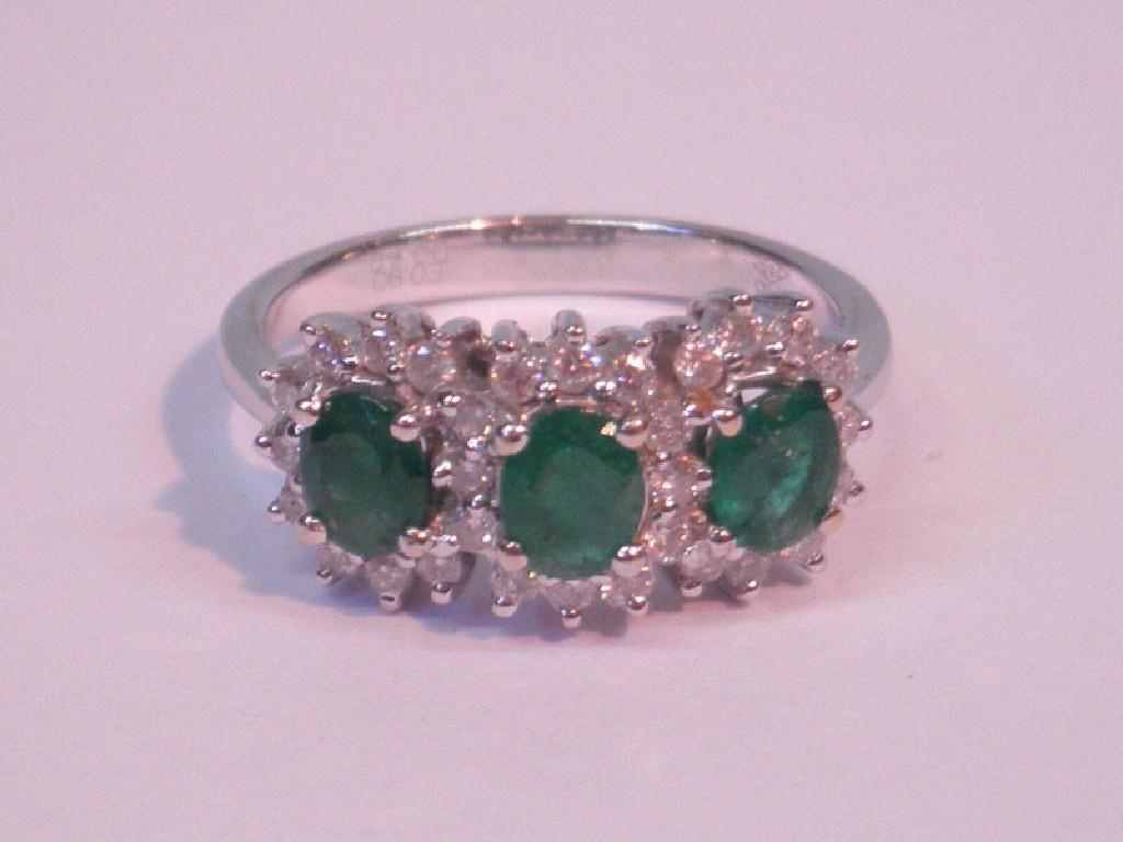 Appraisal: A triple cluster dress ring of three emeralds surrounded by