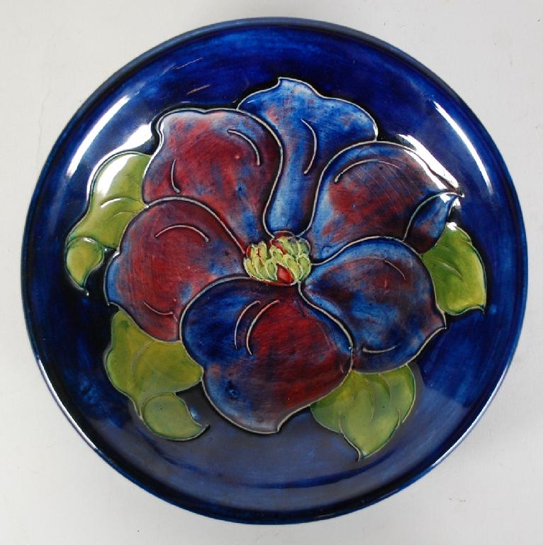 Appraisal: MOORCROFT CLEMATIS PATTERN TUBE LINED CIRCULAR PLAQUE painted blue and