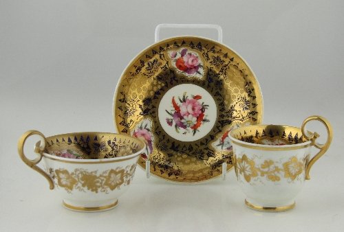 Appraisal: A Spode trio finely painted reserves of summer flowers within