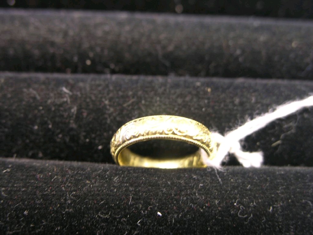 Appraisal: An ct gold band wedding ring with engraved detail ring