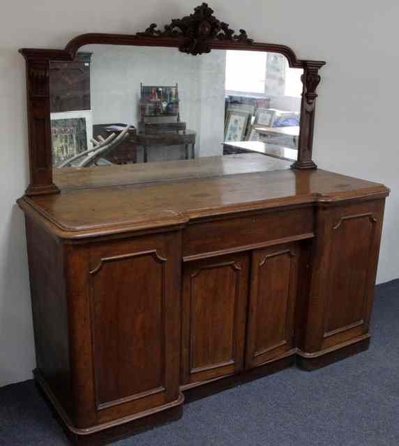 Appraisal: A Victorian oak breakfront sideboard the mirror back with carved