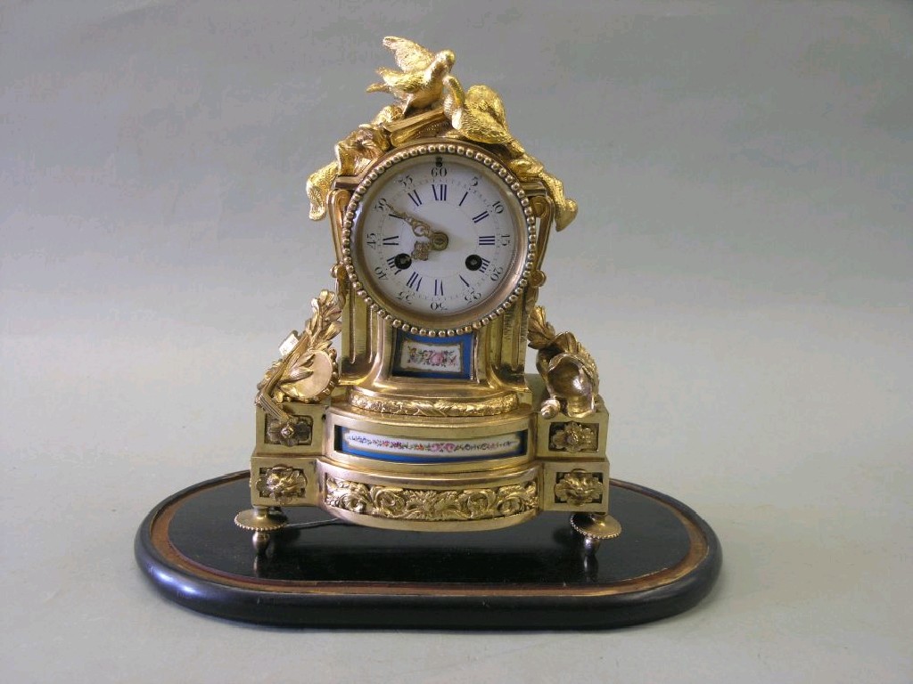 Appraisal: A th century French ormolu mantel clock featuring convex enamel