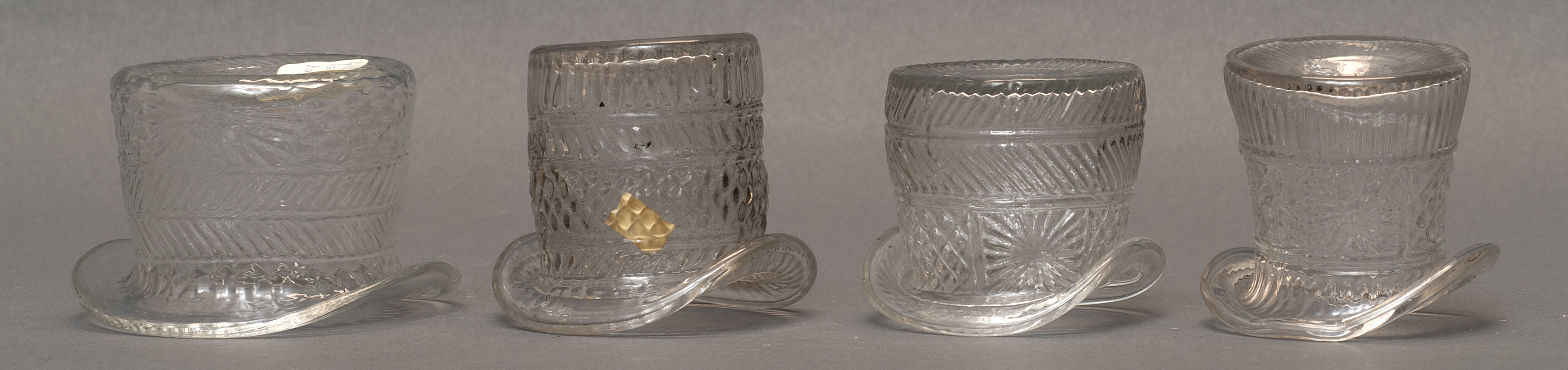 Appraisal: FOUR CLEAR GLASS BLOWN -MOLD HAT-FORM WHIMSEYS Second Quarter of