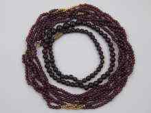 Appraisal: A three row garnet bead necklace with yellow metal tests