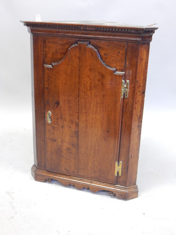 Appraisal: An thC oak corner cabinet with a single arched panelled