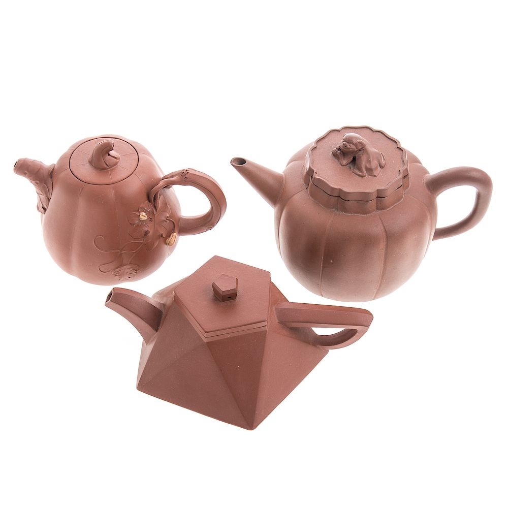 Appraisal: Three Chinese Yixing teapots including two melon-form and a faceted-form