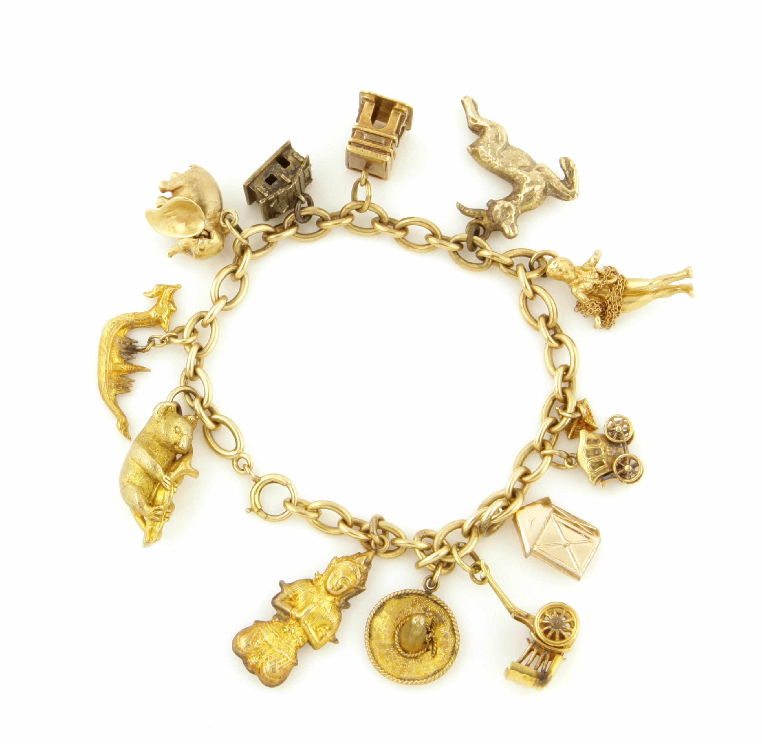 Appraisal: A gold charm bracelet including an elephant kola bear hula