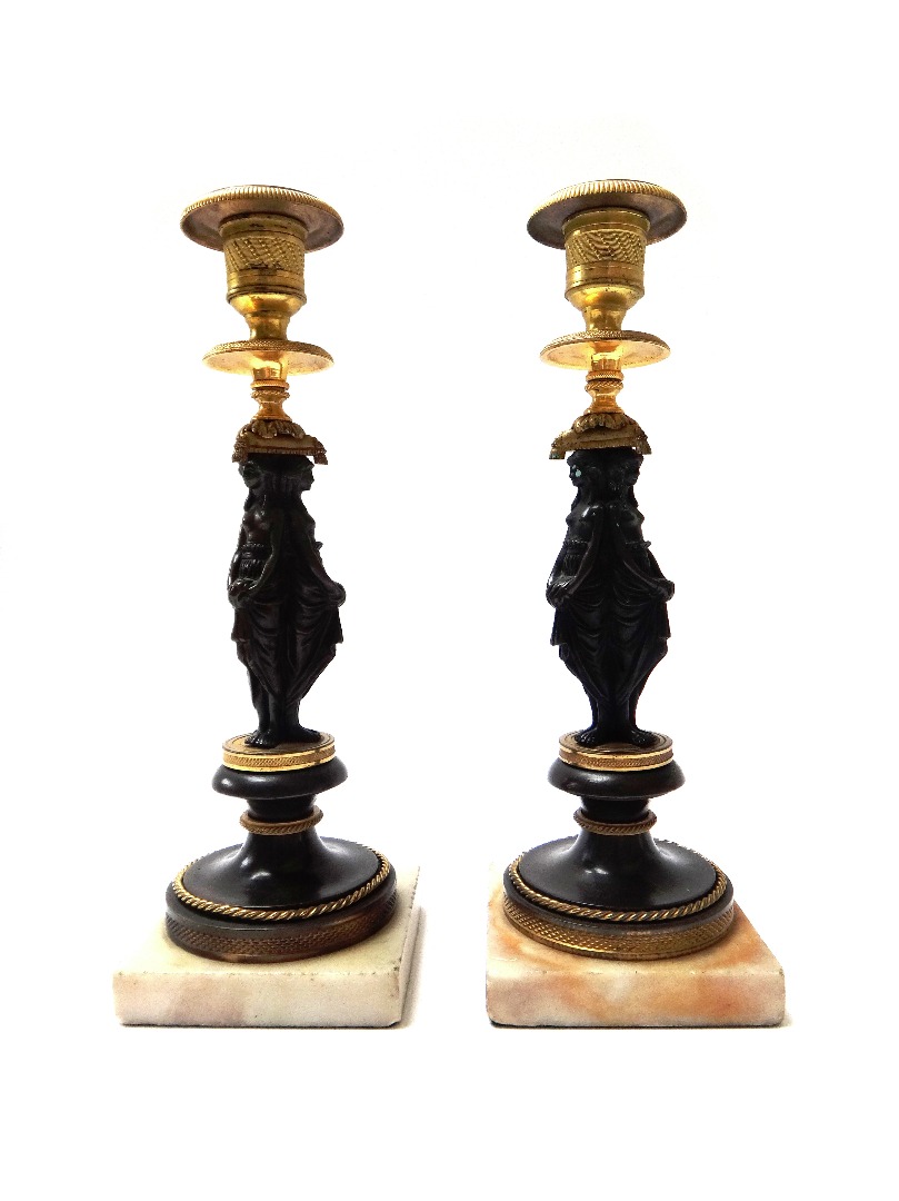 Appraisal: A pair of patinated and gilt bronze figural candlesticks late