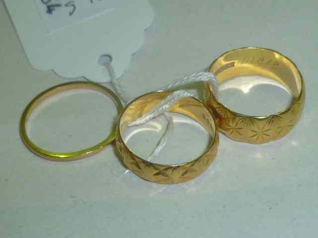 Appraisal: TWO CT GOLD WEDDING BANDS of stylised form grams together