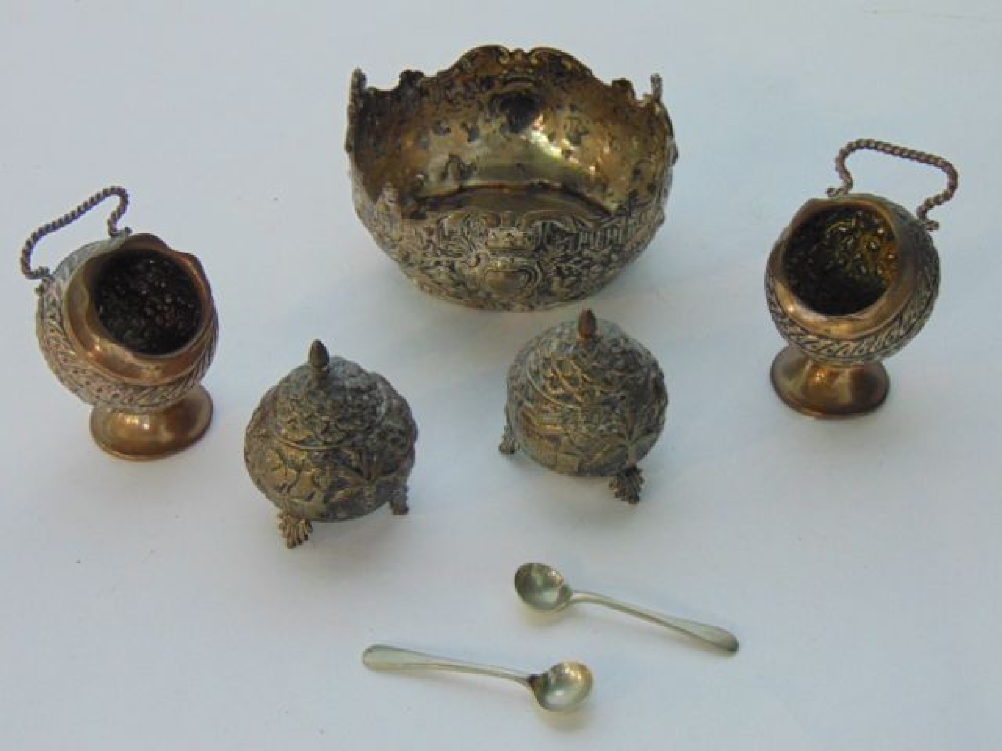 Appraisal: An assembled Eastern white metal cruet set comprising two salt