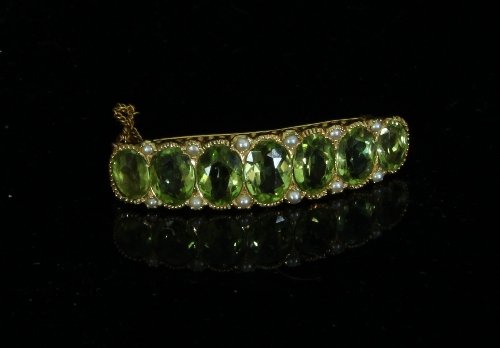 Appraisal: A peridot and seed pearl brooch the seven graduated oval