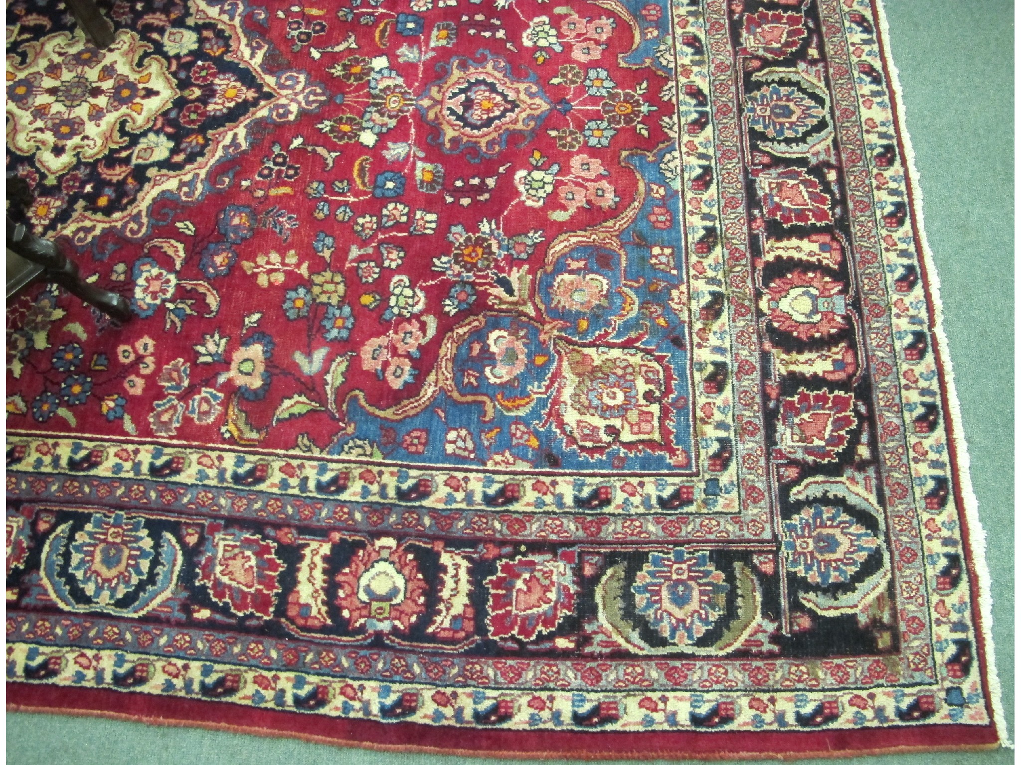 Appraisal: A large meshed red ground rug with foliate decoration x