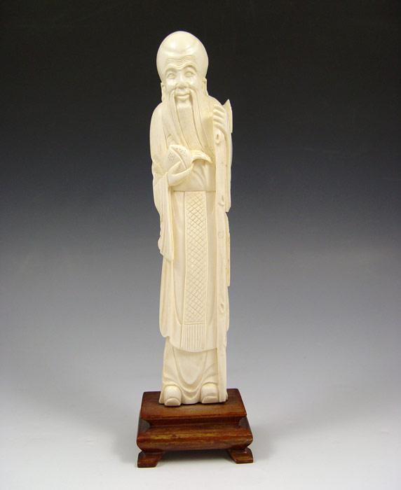 Appraisal: CARVED IVORY FIGURE OF AN ELDER Man holding staff and