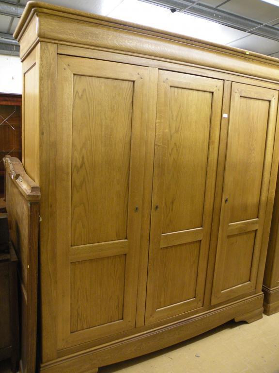 Appraisal: A French style oak triple wardrobe on bracket feet