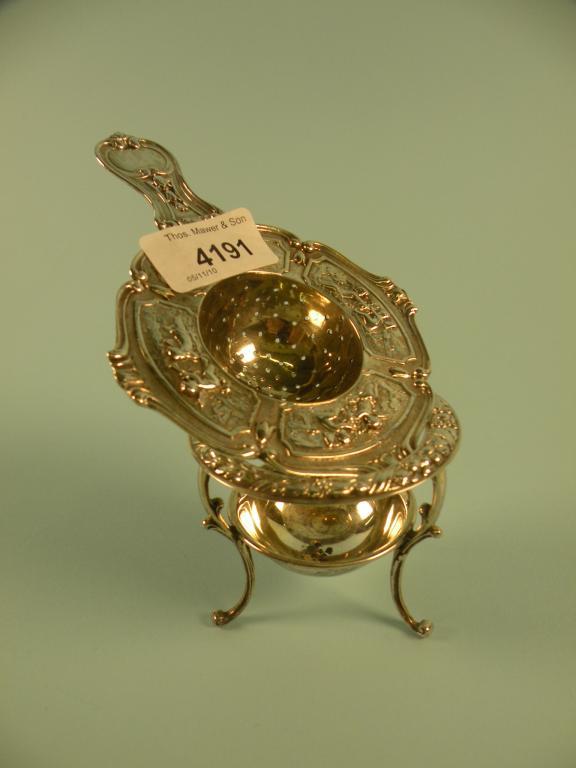 Appraisal: A Continental white metal tea strainer and stand and associated