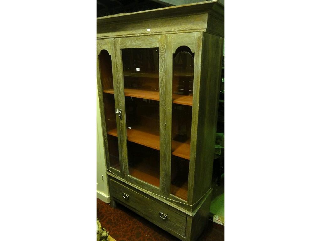 Appraisal: A limed oak display cabinet with stepped and moulded cornice