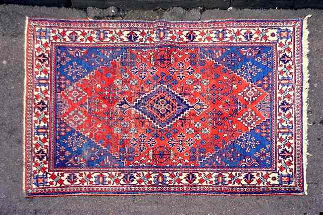 Appraisal: AN OLD PERSIAN JOSHEGAN RUG decorated geometric motifs on a