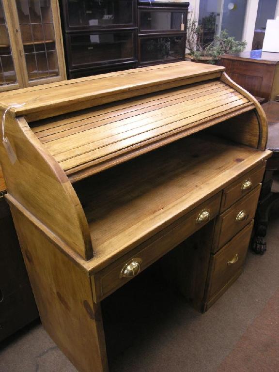 Appraisal: A waxed pine roll top desk tambour shutter enclosing plain