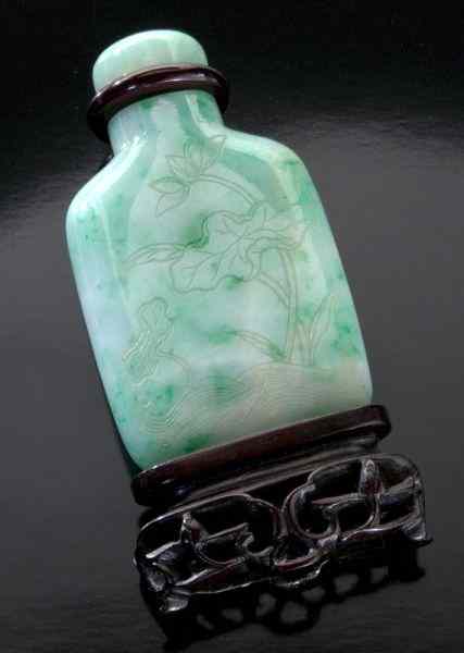 Appraisal: Chinese Qing carved jadeite snuff bottledepicting lotus and bamboo with