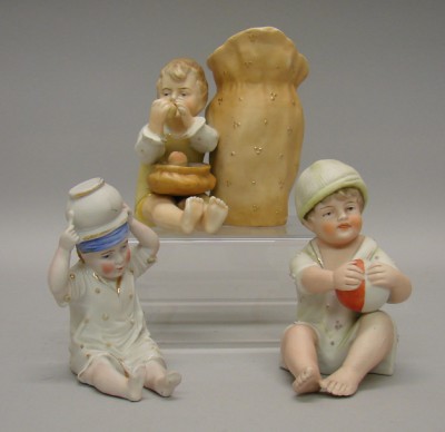 Appraisal: Lot of unmarked bisque boy piano babies Sitting with upside