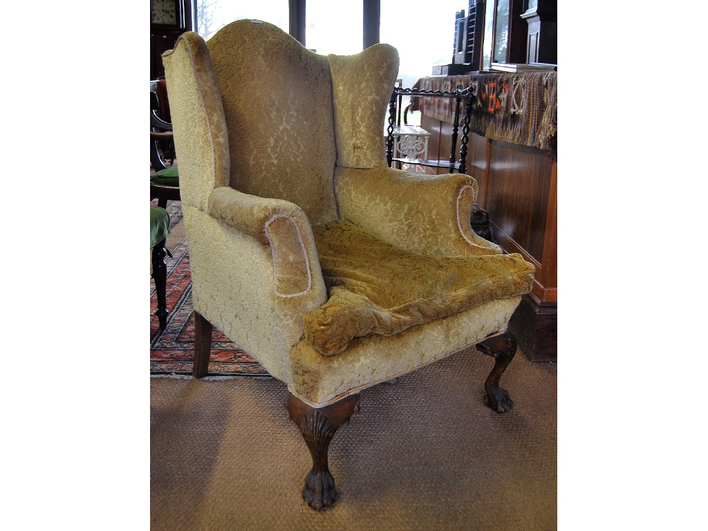 Appraisal: A George II style upholstered wing armchair raised on hipped