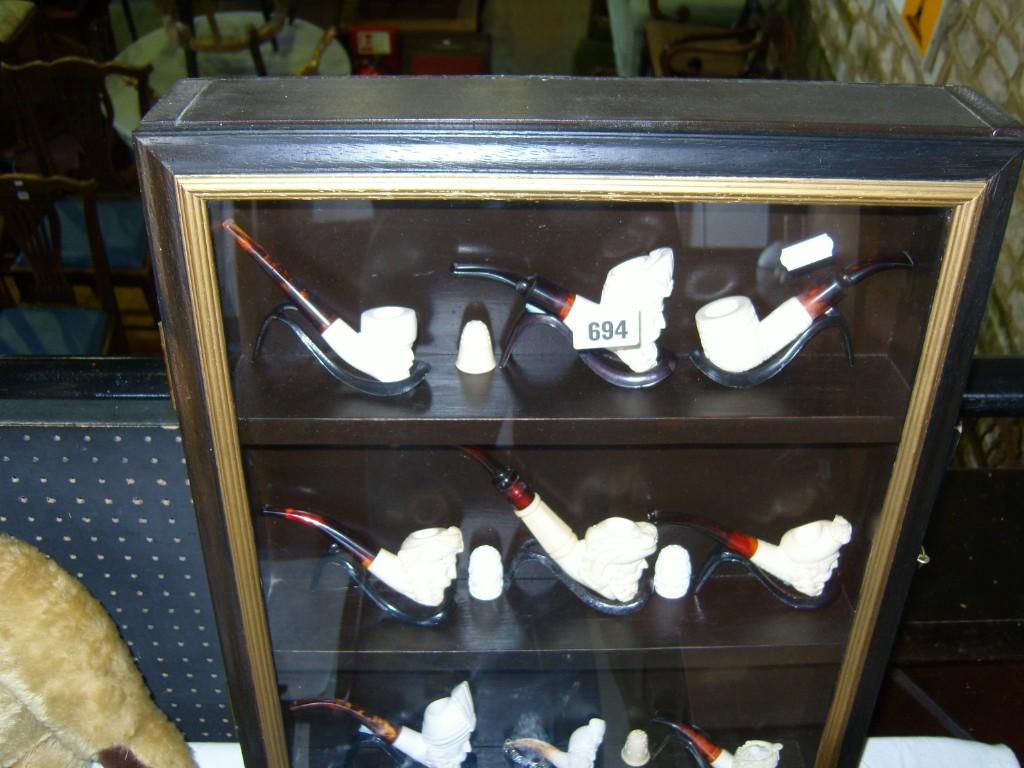 Appraisal: A cabinet enclosing a selection of recent Meerschaum style pipes