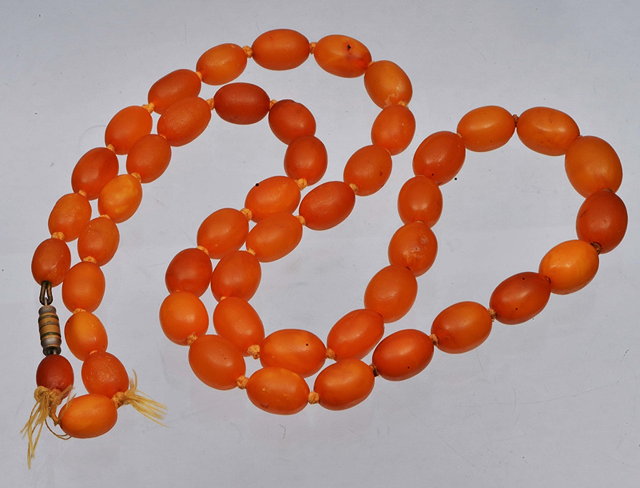 Appraisal: AN OVAL RECONSTITUTED AMBER BEAD NECKLACE long mm bead down