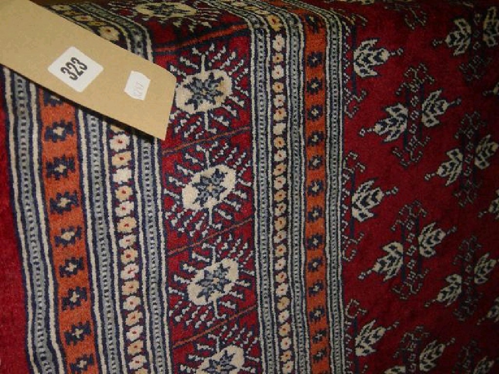 Appraisal: A red ground Eastern wool rug with repeating decoration in