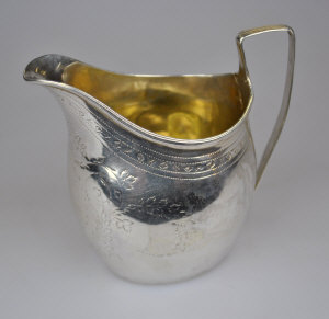 Appraisal: A George III silver helmet cream jug with engraved decoration