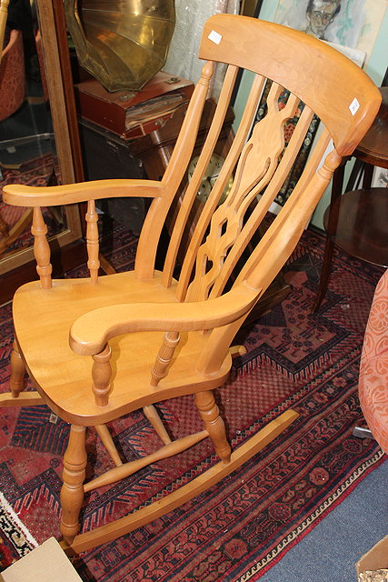 Appraisal: A BEECHWOOD WINDSOR STYLE ROCKING CHAIR with pierced splat back