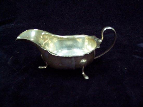 Appraisal: A sauce boat with serrated border and C scroll handle