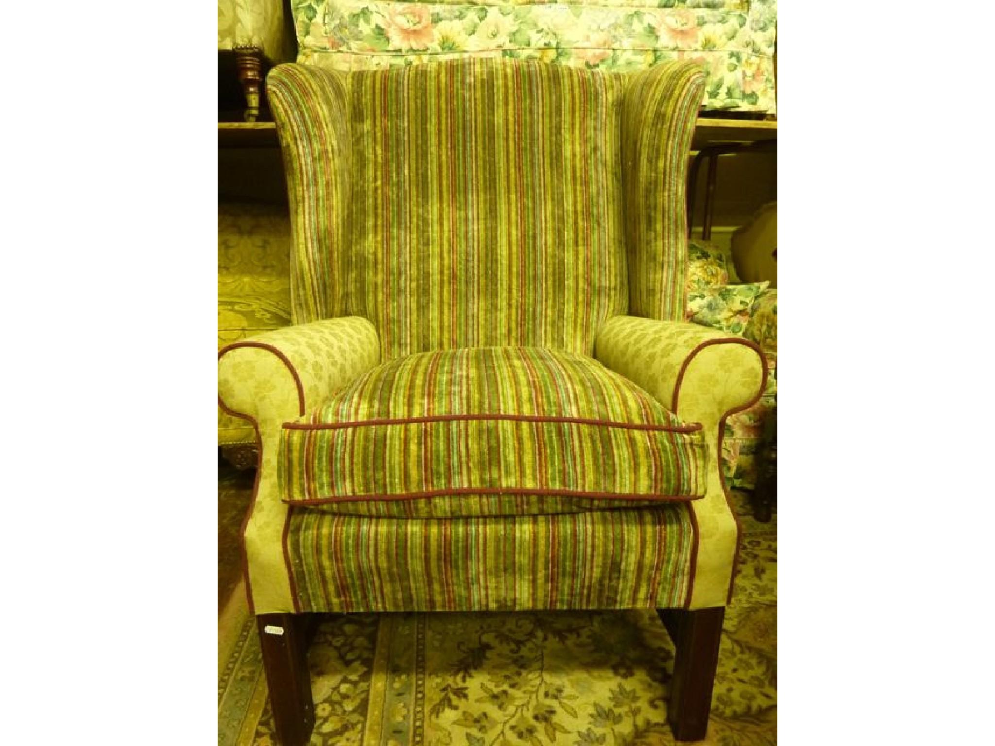 Appraisal: A Georgian style wing armchair with shaped outline stylised upholstered