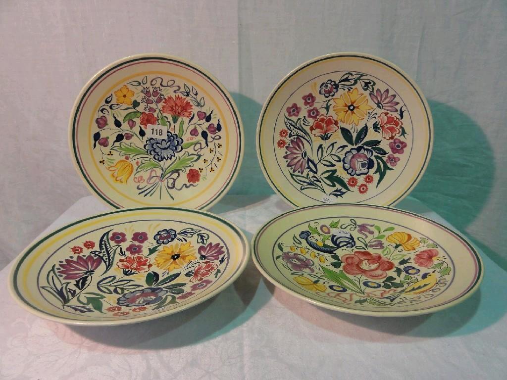 Appraisal: Four Poole Pottery chargers in white earthenware with various elaborately