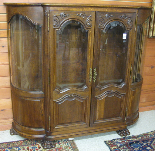 Appraisal: AN OAK AND CURVED GLASS CHINA CABINET French c centering