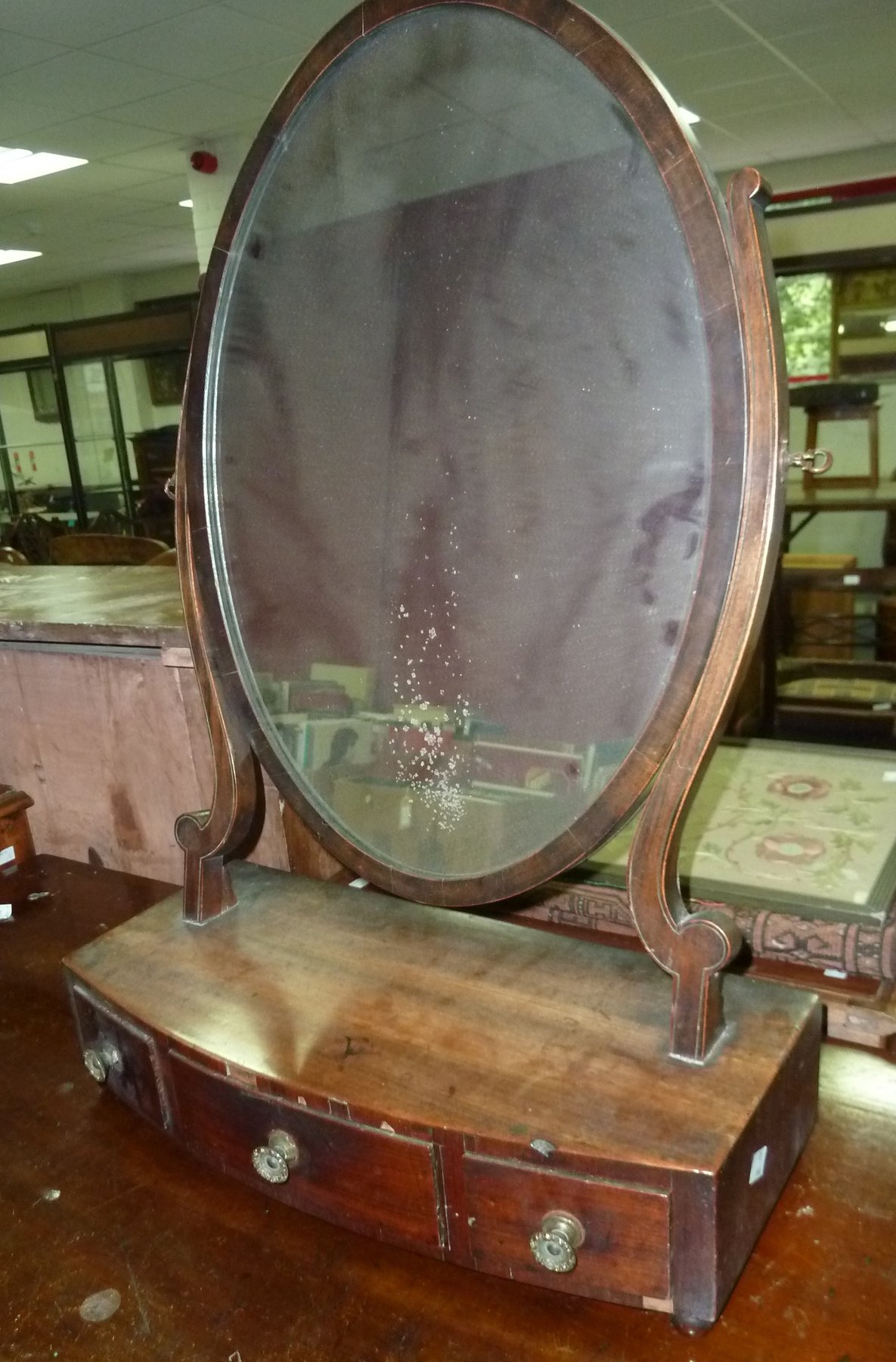 Appraisal: A mahogany oval swing frame toilet mirror the bow front