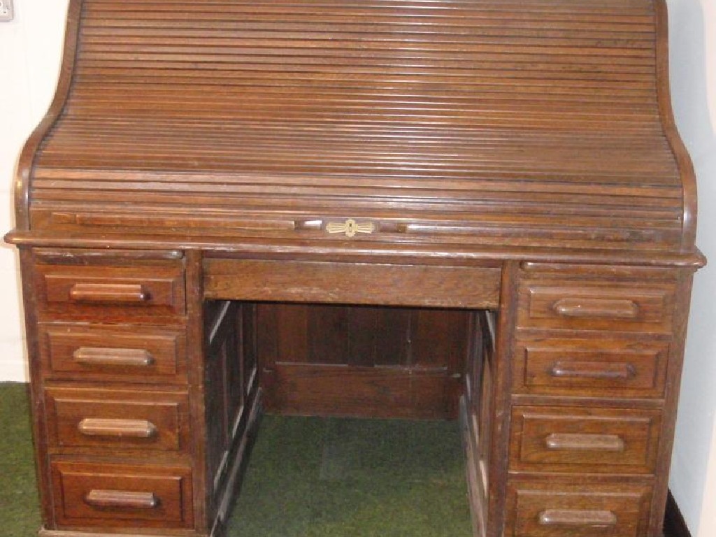 Appraisal: An oak roll top desk with s shape tambour revealing