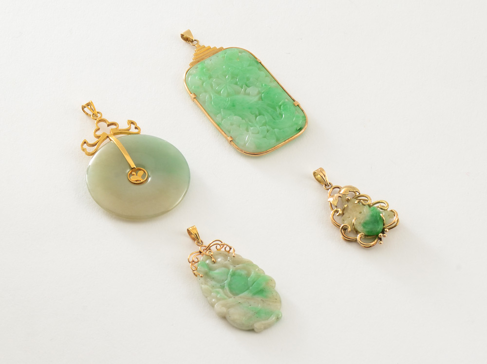 Appraisal: FOUR JADEITE JADE PENDANTS K yellow gold mountings Disc ''