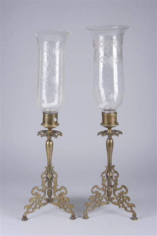 Appraisal: TWO CANDLESTICKS WITH ETCHED GLASS HURRICANES SHADES Scrolling tripod base