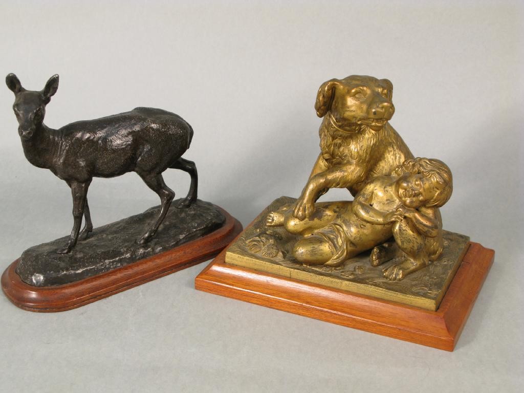 Appraisal: A lacquered bronze model dog guarding a sleeping child on