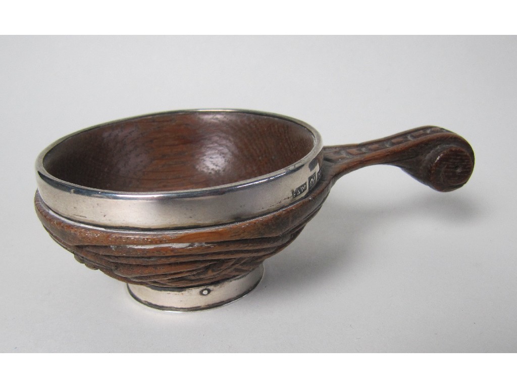 Appraisal: A silver mounted and carved oak quaich the central boss