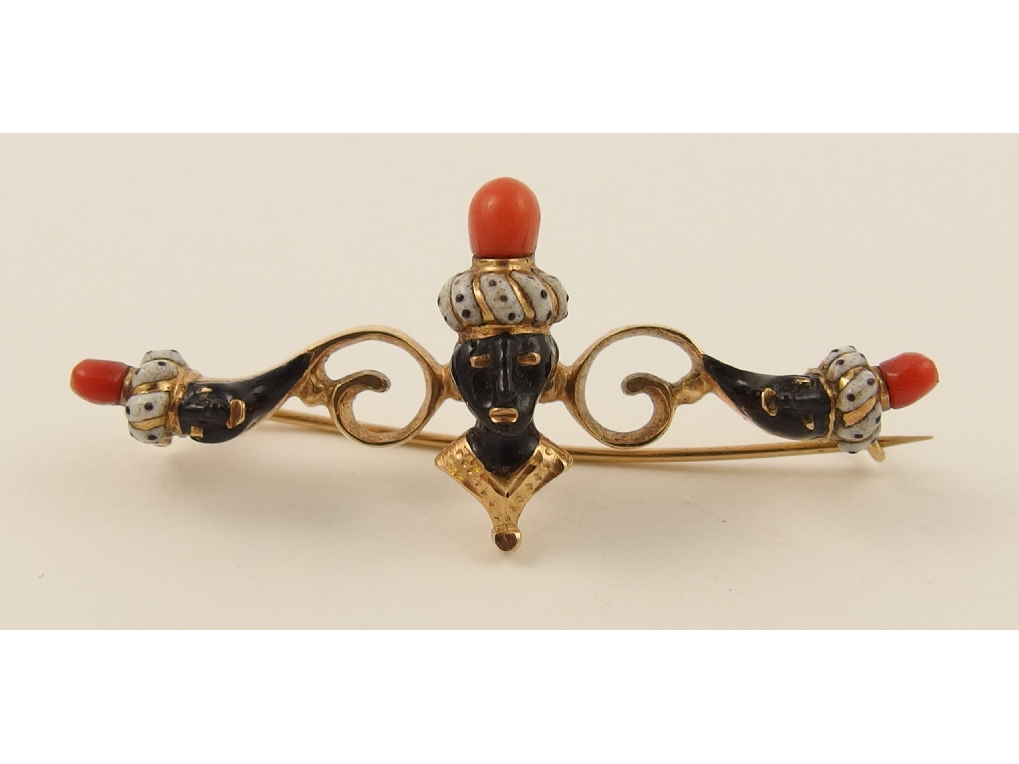 Appraisal: An enamelled Blackamoor brooch in scrolling yellow metal further set