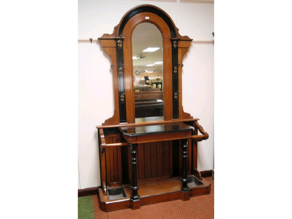 Appraisal: A late Victorian oak ebonised hall stand with arched mirrored