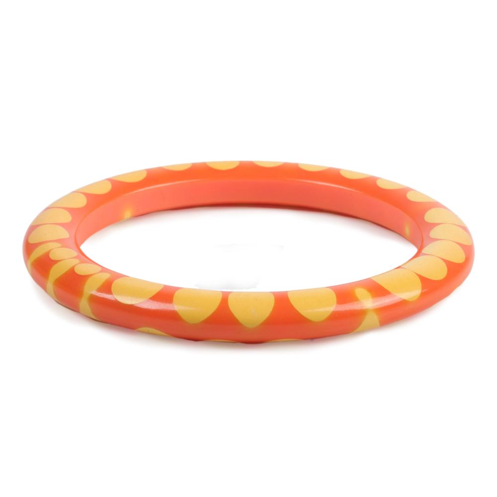 Appraisal: BAKELITE ORANGE AND CREAM RANDOM DOT BANGLE BRACELET INNER DIAM