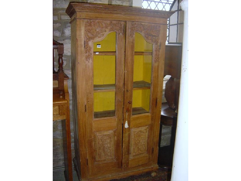 Appraisal: A hardwood side cupboard enclosed by a pair of doors