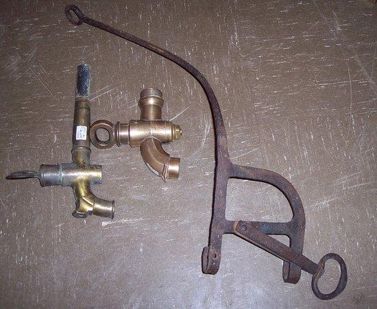 Appraisal: A wrought iron chimney stand and two brass head taps