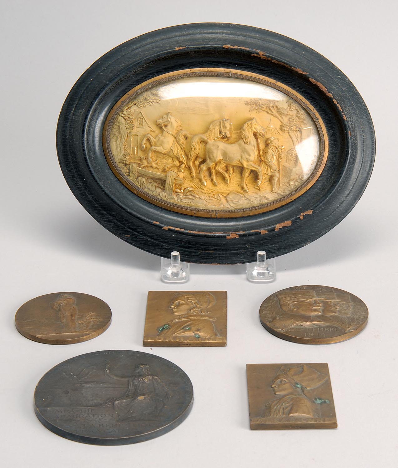 Appraisal: FIVE SMALL BRONZE PLAQUES together with an oval-framed gilt-brass plaque