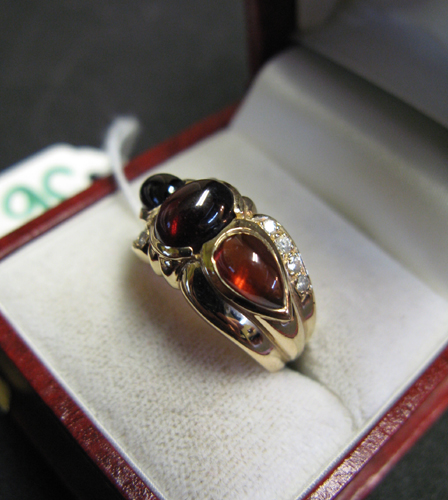 Appraisal: GARNET DIAMOND AND FOURTEEN KARAT GOLD RING centering an oval